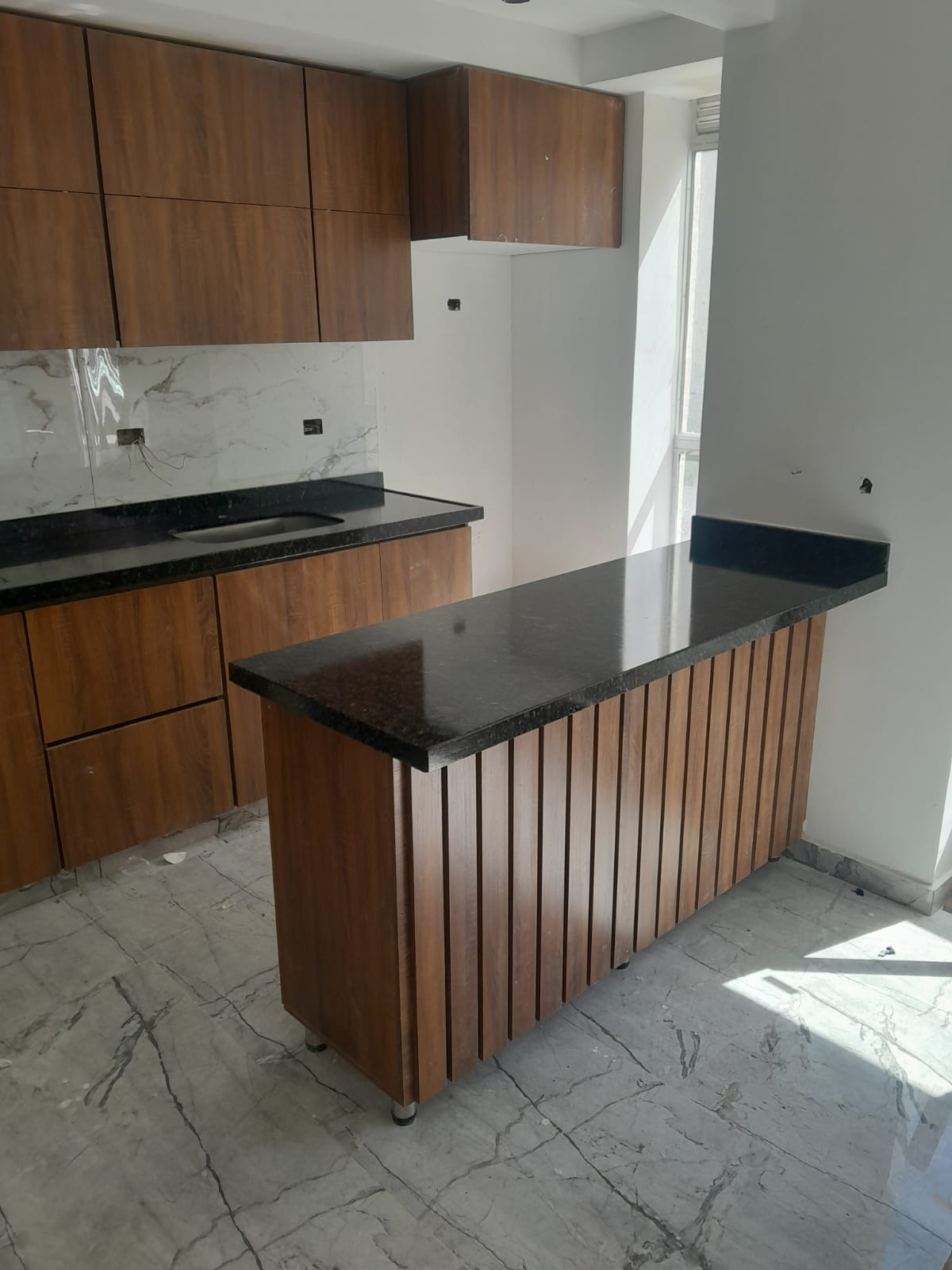 Isla de cocina en madera con mesón negro